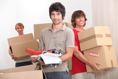 Removalists carrying furniture through a Westminster apartment building entrance